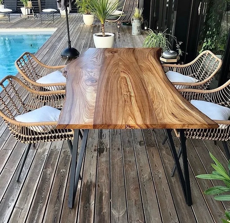Table en bois brut avec piétement métal en terrasse
